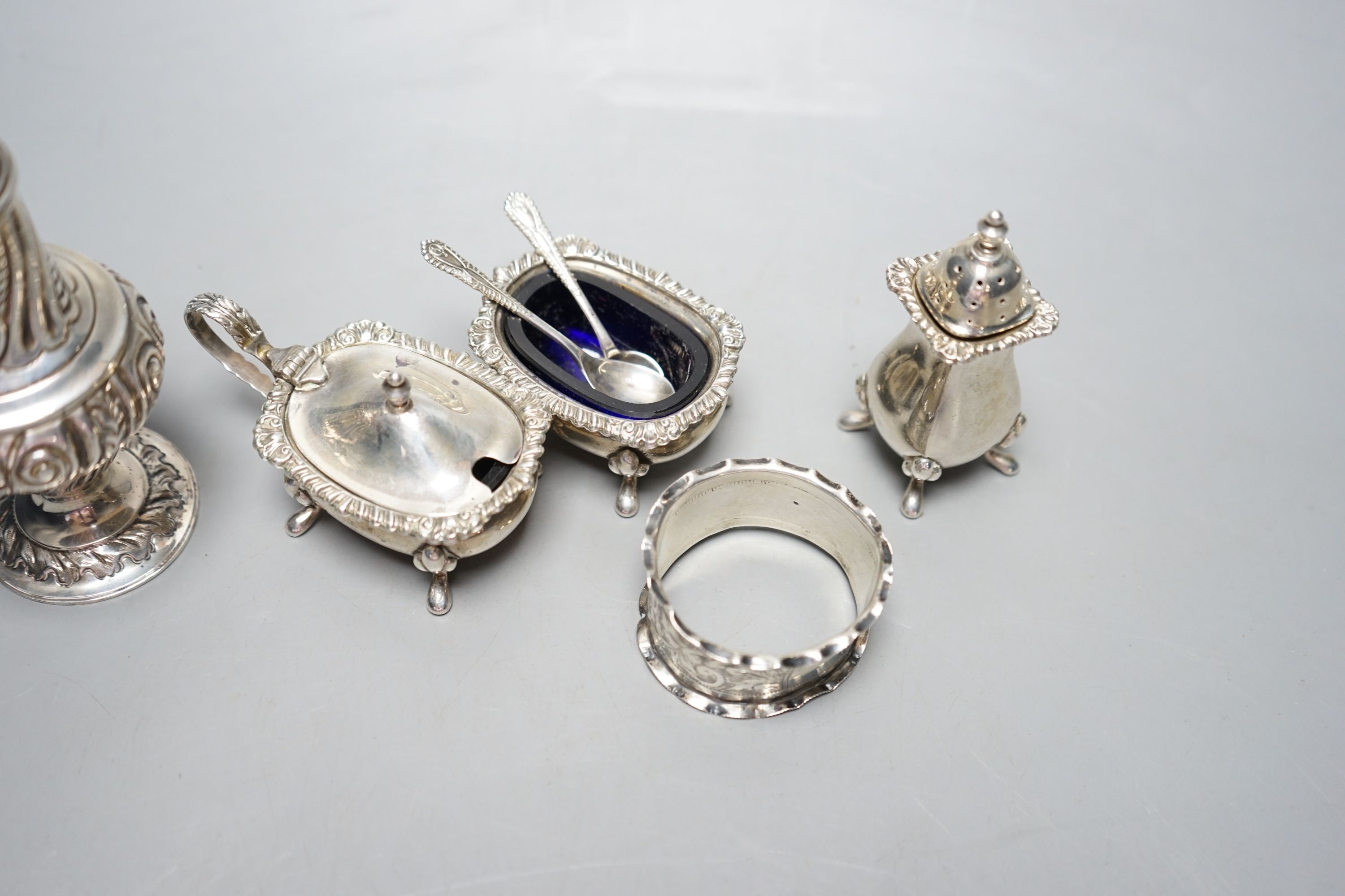 An Edwardian silver sugar sifter, Birmingham, 1901, a silver three piece condiment set and a silver napkin ring.